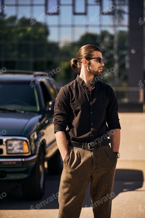 Preview: eye catching young man with accessories posing next to his car with hands in pockets, sexy driver