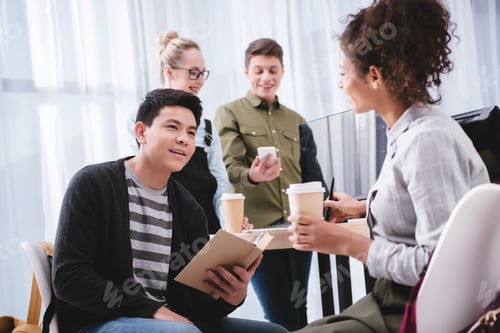 Preview: young multicultural teenagers studying and drinking coffee