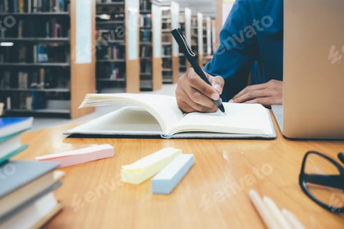 Preview: Close up hands with pen writing on notebook.