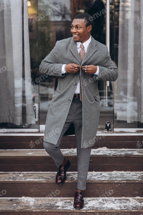 Preview: Confident man buttoning overcoat standing on steps