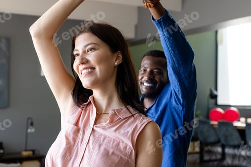 Preview: Couple dancing joyfully at home, celebrating with smiles and raised arms