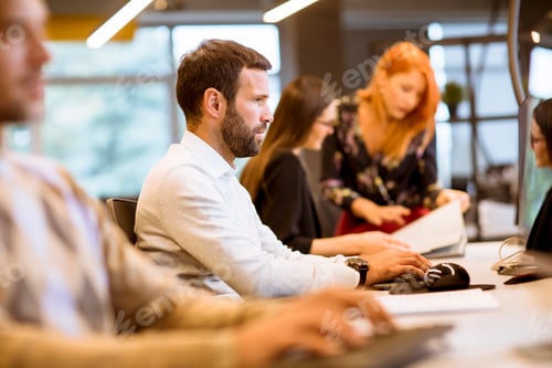 Preview: Young business people working in office