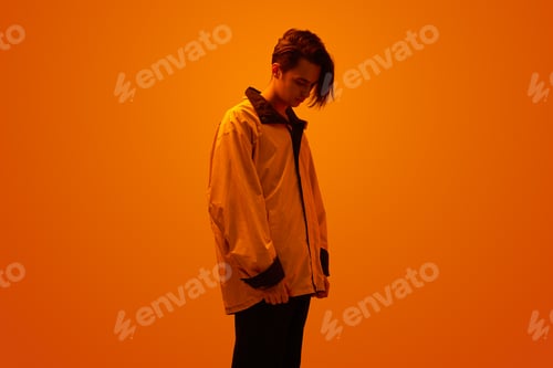 Preview: Stylish teenager under neon orange light
