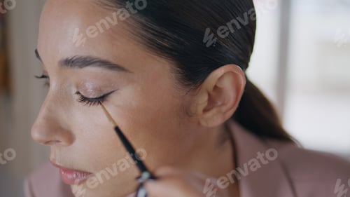 Preview: Closeup woman applying eyeliner makeup at room interior. Lady face drawing eyes