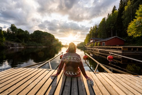 Preview: Finland, Kajaani, Man sitting on jetty, watching sunset, rear view