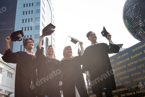 Preview: Low angle view of multiethnic students celebrating graduation ceremony