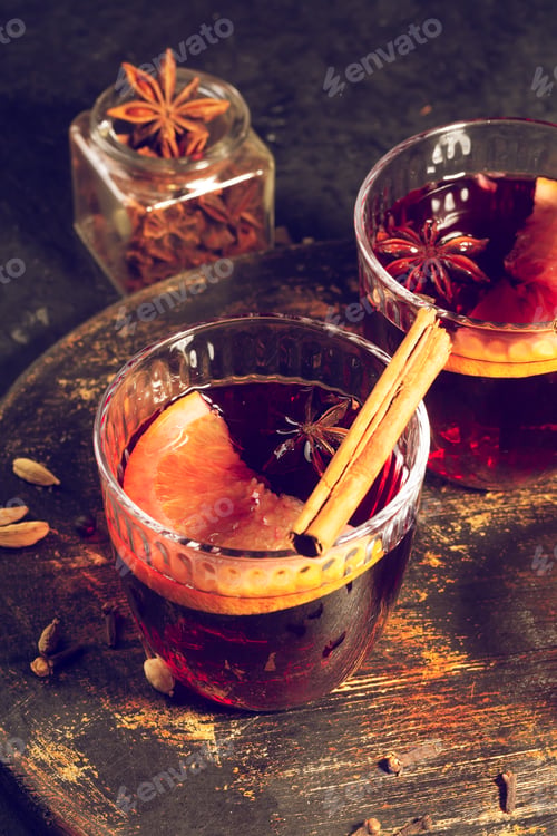 Preview: Mulled wine with slice of orange and spices on a wooden background, toned image