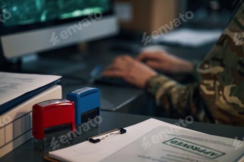 Preview: Person Working at Desk with Computer and Paperwork