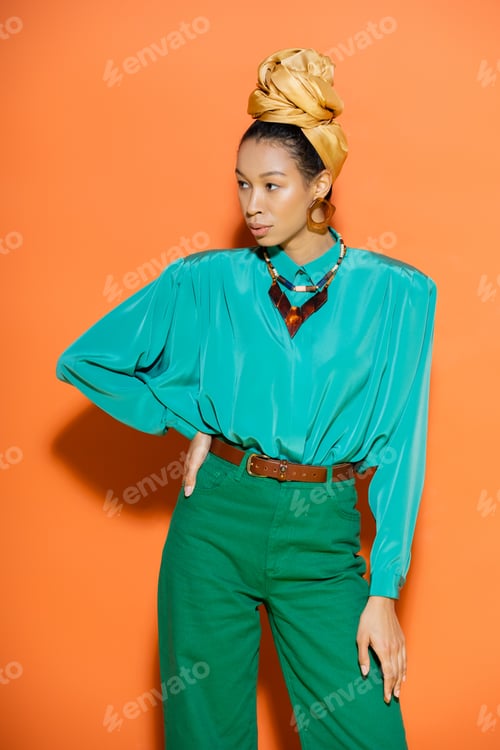 Preview: Trendy african american woman in summer clothes looking away on orange background