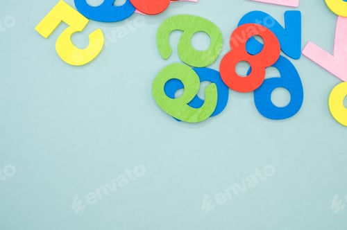 Preview: Flat lay of colorful wooden numbers on a blue surface - space for text