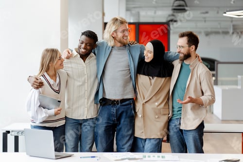 Preview: Group of five diverse business people smiling and posing for a photo in their modern office
