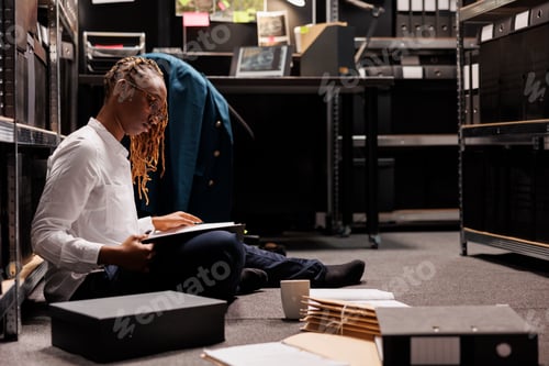 Preview: African american woman detective reviewing case file on floor