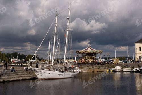 Preview: Beautiful white ship docked in Honfleur port with other boats in the back, under cloudy sky