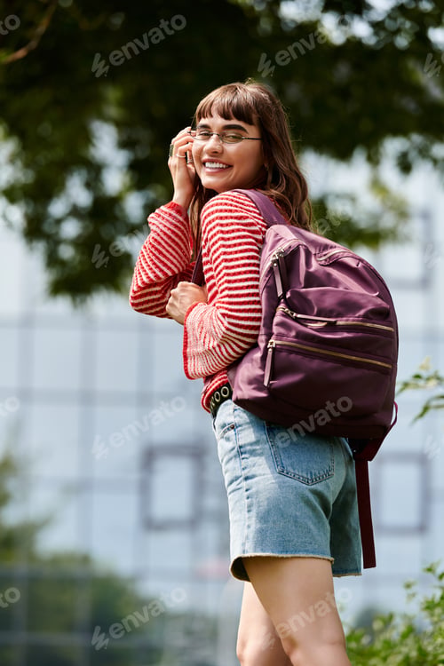 Preview: Young female student enjoying a bright day on campus while carrying a stylish backpack