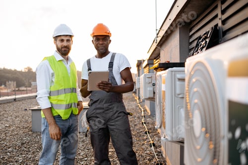 Preview: Managers using tablet for work with cooling system on roof