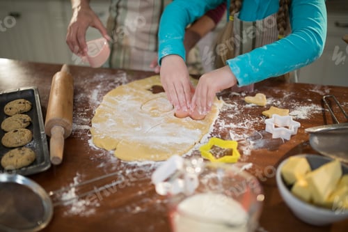 Preview: Mother and daughter preparing cookies in kitchen