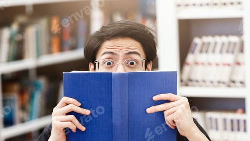 Preview: Scared korean guy hiding behind book in library