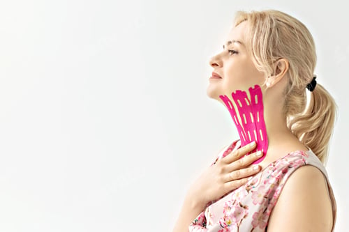 Preview: A woman in a pink dress with a pink tape pasted on the skin of her neck. lymphatic drainage effect