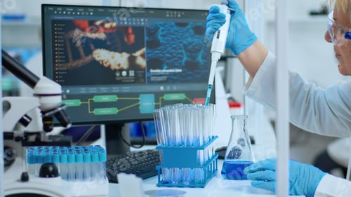 Preview: Close up of researcher testing liquid sample using micropipette