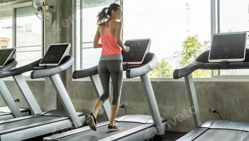 Preview: Female exercising with personal trainer at gym