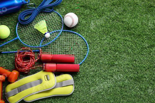 Preview: Set of different colorful sports equipment on green grass, above view. Space for text