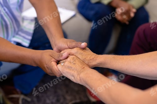 Preview: Cropped image of multiracial senior friends holding hands and comforting in group therapy session