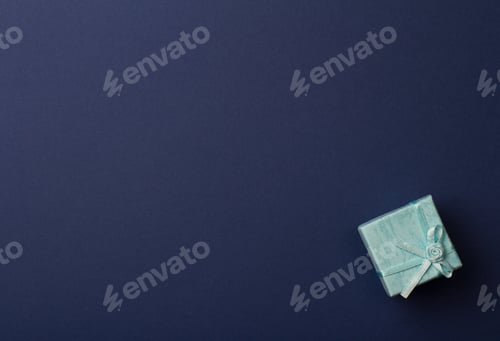 Preview: small gift box on dark blue paper background