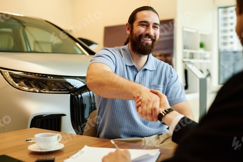 Preview: Smiling Male Buyer Shaking Hands with Auto Dealer at Dealership Center