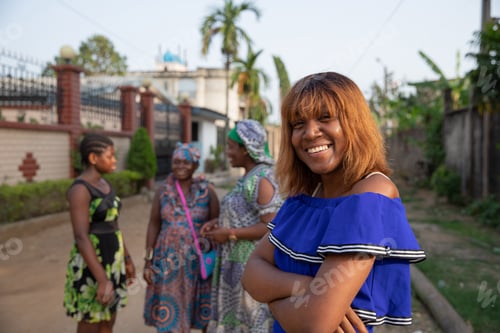 Preview: Portrait of an isolated african girl with three other women in the background talking to each other