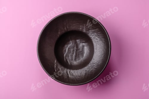 Preview: An empty round ceramic plate on a pink background as a kitchen utensil. An empty plate