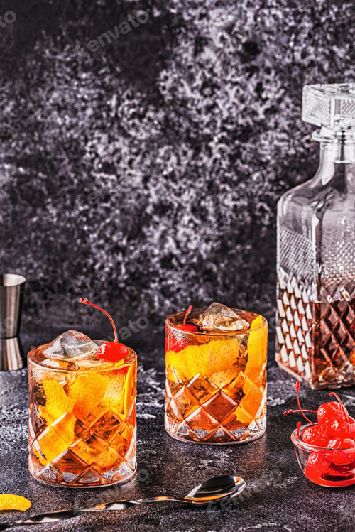 Preview: Old fashioned cocktail with cherries and orange twist.
