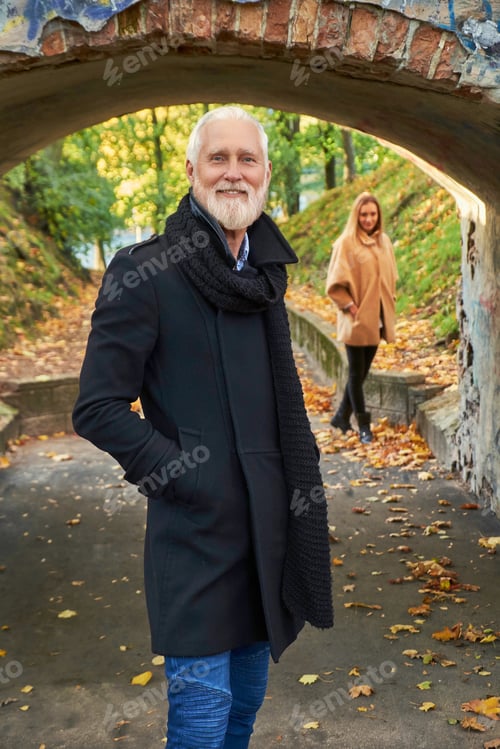 Preview: Joyful grandfather with his granddaughter posing under arch