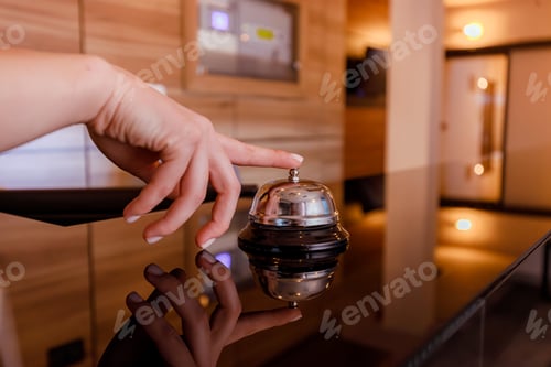 Preview: Guest ringing service bell at hotel reception during daytime