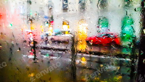Preview: blurred view of glass with drops under the rain