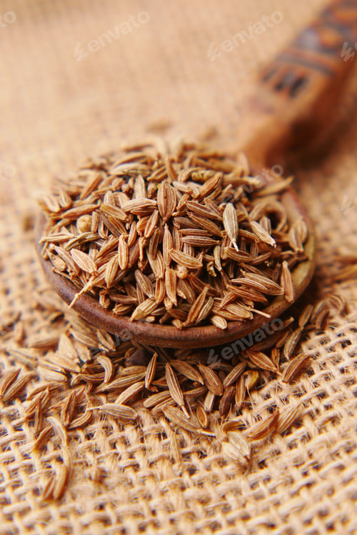 Preview: cumin seeds on spoon on table , close up