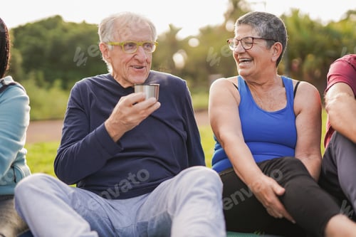 Preview: Joyful elderly people drinking hot tea together after yoga class at city park
