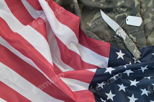 Preview: Army dog tag token and knife lies on Old Camouflage uniform and folded United States Flag