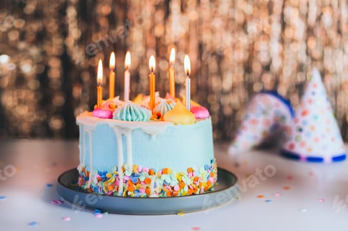 Preview: Colorful birthday cake with sprinkles and burning candles on a golden tinsel wall background.