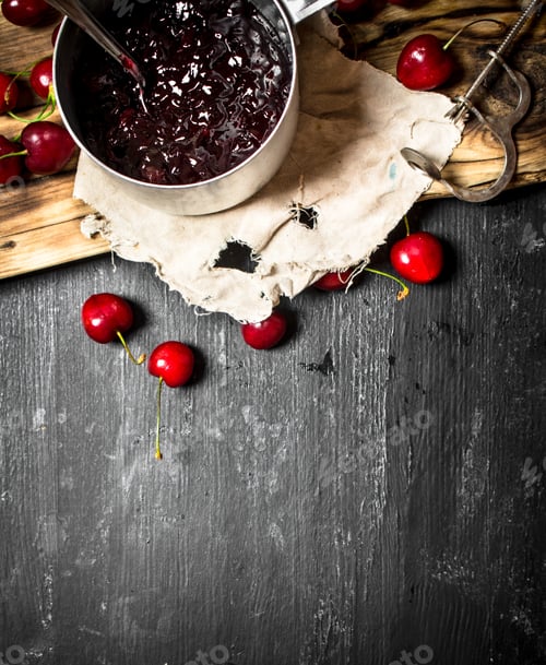 Preview: Fresh cherry jam in a saucepan on old Board.