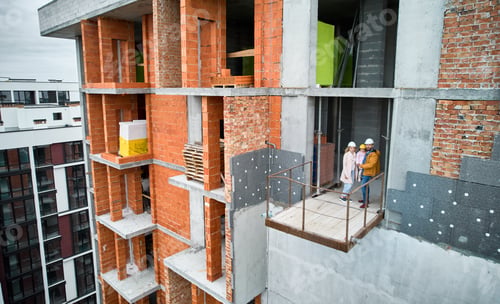 Preview: Family standing inside building under construction.