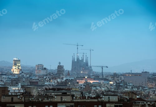 Preview: Elevated hazy cityscape view with La Sagrada Familia and construction cranes, Barcelona, Spain