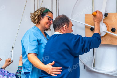 Preview: Physiotherapist helping a man to exercise with modern machine at geriatrics
