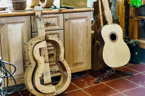 Preview: Wooden mould for making Spanish flamenco guitar, next to unfinished guitar, in luthier workshop.