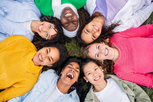 Preview: Multiracial group of young women in circle smiling at camera together