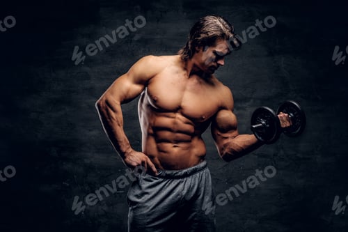 Preview: Attractive muscular man is posing with dumbbell