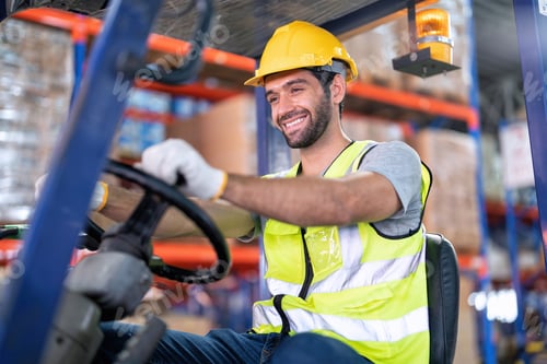 Preview: Forklift Truck Operator Lifts Pallet Cardboard Boxes On a Shelf by Trucks smiling portrait
