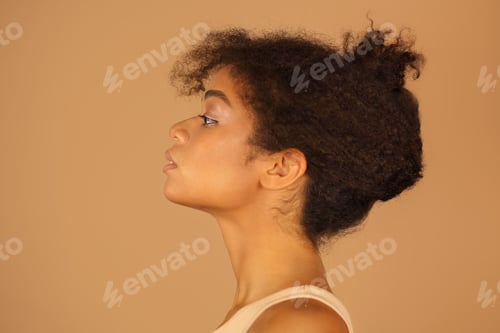 Preview: Profile view of young confident african american woman with healthy clear skin and curly hair