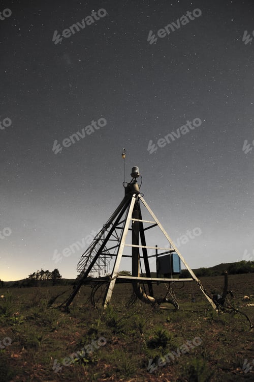 Preview: Vertical shot of an antenna space against a starry bight sky background