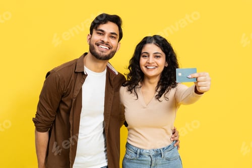 Preview: Happy Couple Holding Credit Card On Yellow Background