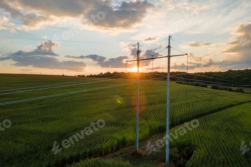 Preview: High voltage tower with electric power lines between green agricultural fields